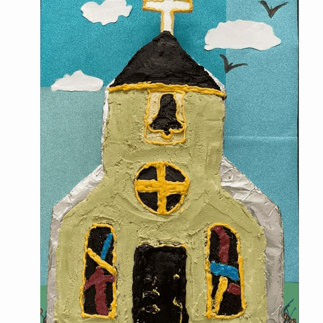 A handmade church model with painted windows and a cross on top.