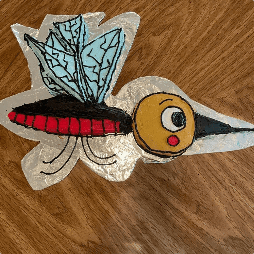 A colorful, stylized bird craft with blue wings and a red-striped body.