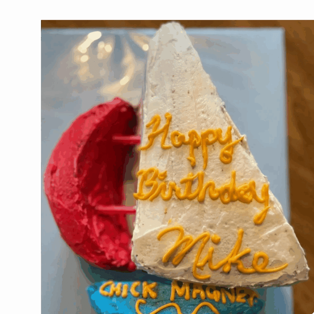 Birthday cake with red and white frosting and yellow writing.