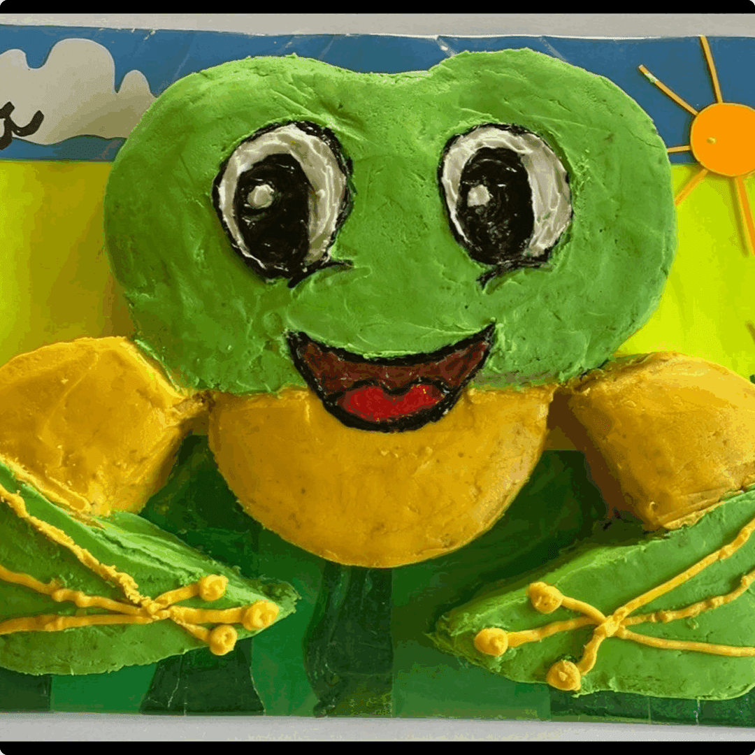 A colorful frog craft made with green, yellow, and black materials.