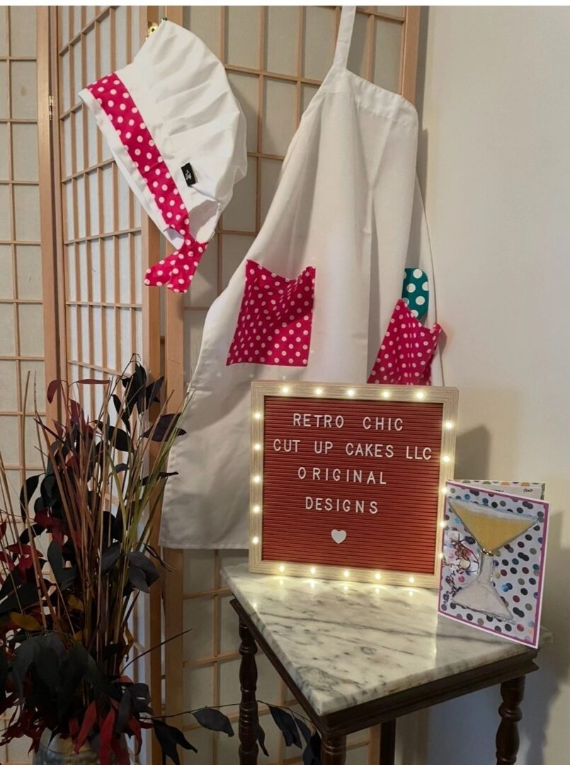 Handmade aprons with colorful pockets hanging on a rack.