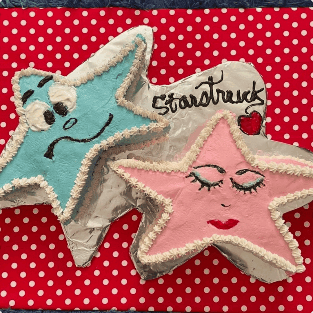 Two handmade felt star ornaments with facial expressions and embroidery.