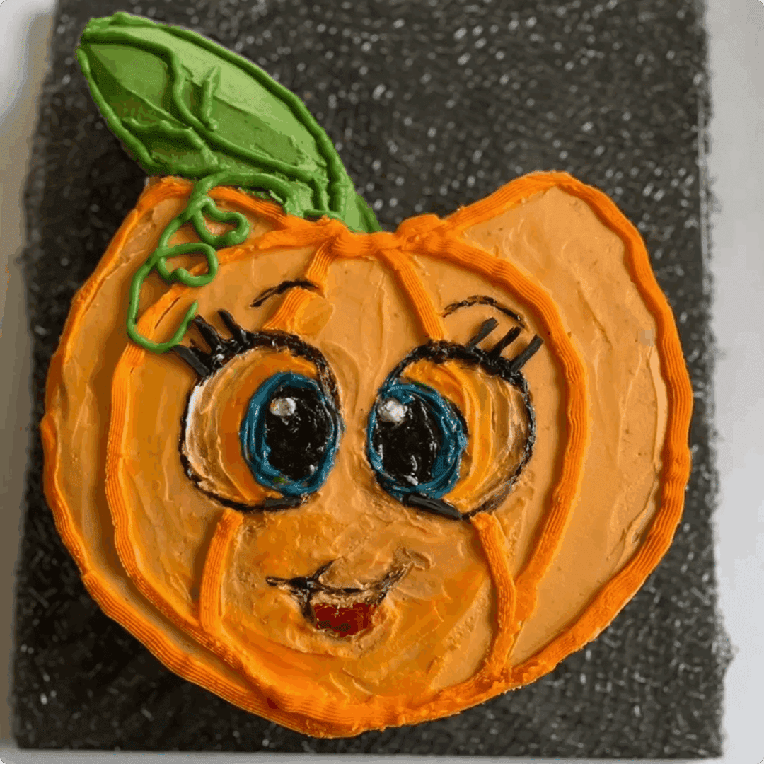 Cute embroidered pumpkin with big eyes and a green leaf.