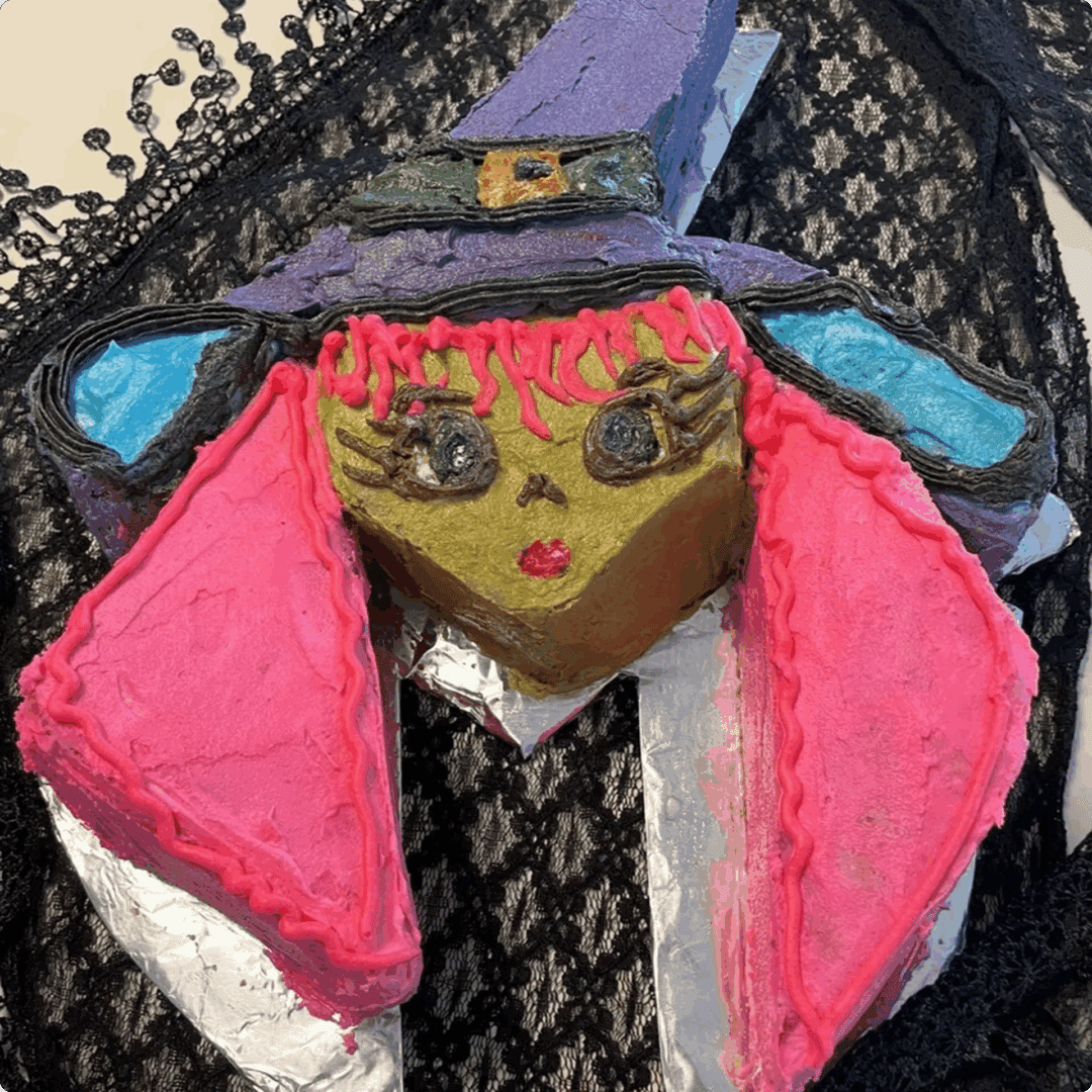 A colorful handmade doll with a pink headdress and painted face.
