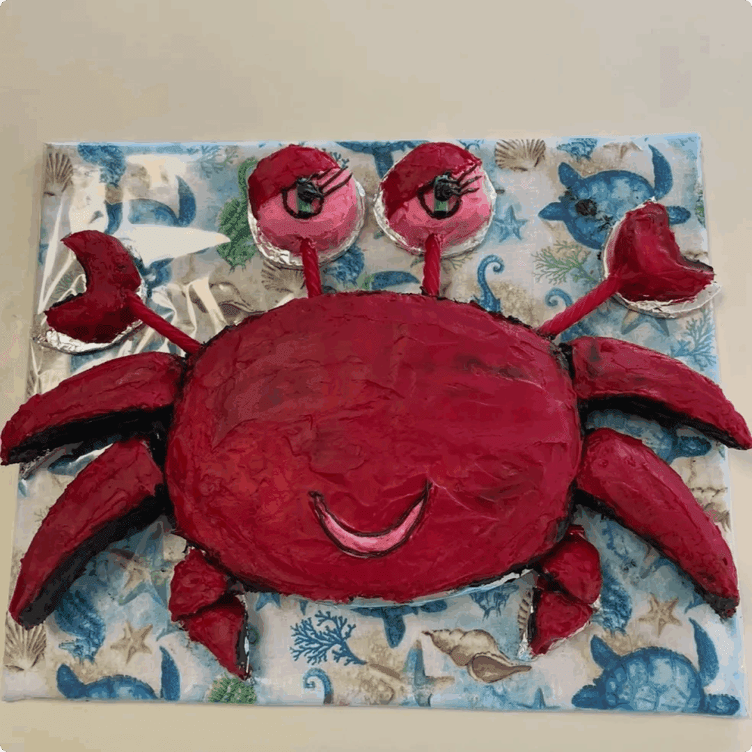 A cheerful red crab sculpture on a blue and white patterned background.