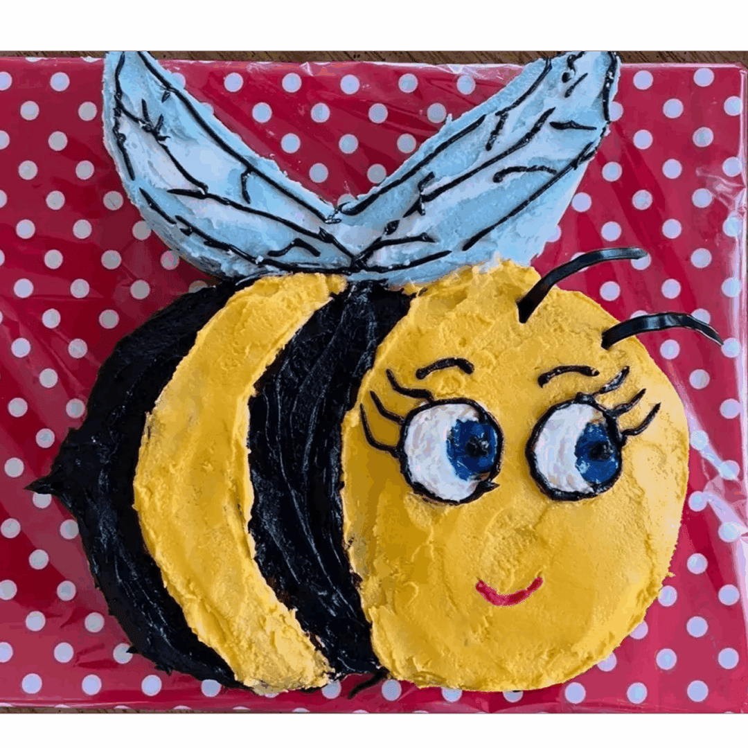 A cute, smiling bee with big eyes and blue wings on a red polka dot background.